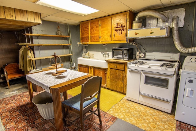 917 Whitewater Ave, Fort Atkinson, WI 53538 - kitchen featuring gas range gas stove, washer / clothes dryer, a sink, black microwave, and brown cabinets
