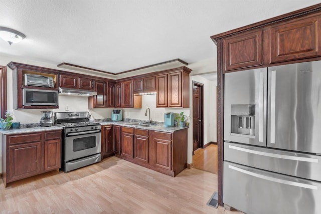 2049 S 77th St, West Allis, WI 53219 - kitchen with stainless steel appliances, a sink, under cabinet range hood, light wood-style floors, and light stone countertops