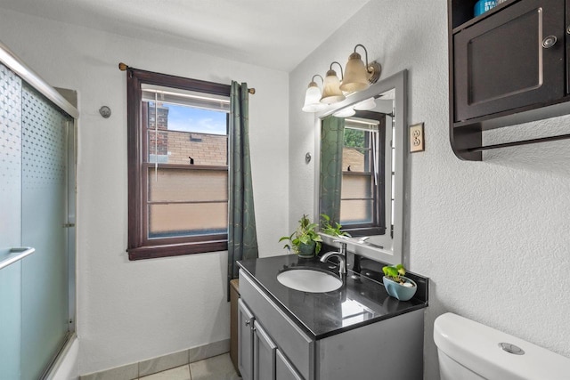 2049 S 77th St, West Allis, WI 53219 - bathroom featuring an enclosed shower, toilet, vanity, and tile patterned flooring