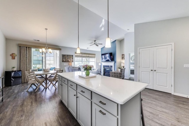 311 Bowing Way, Lake Geneva, WI 53147 - kitchen featuring a fireplace, dark wood-style flooring, lofted ceiling, gray cabinets, and a kitchen island