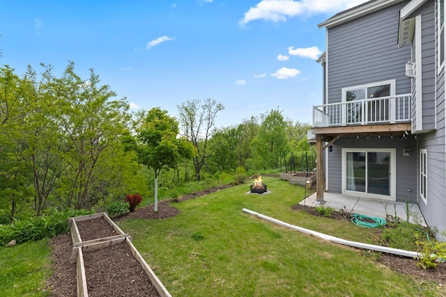 529 Century Oak Dr, Waukesha, WI 53188 - view of green lawn featuring a garden, a fire pit, a patio, and a balcony
