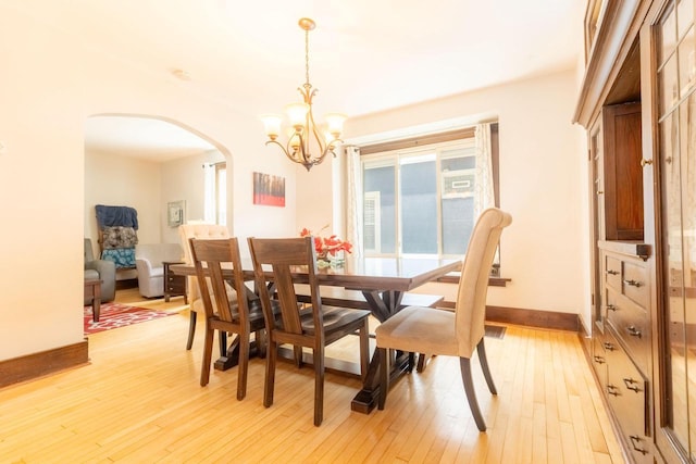 150 S James St, Waukesha, WI 53186 - dining room featuring arched walkways, a chandelier, light wood-style flooring, and baseboards
