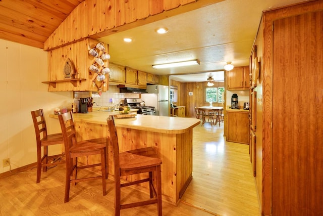 W2761 49th St, Mauston, WI 53948 - kitchen featuring stainless steel gas range oven, freestanding refrigerator, light wood-style flooring, light countertops, and a peninsula