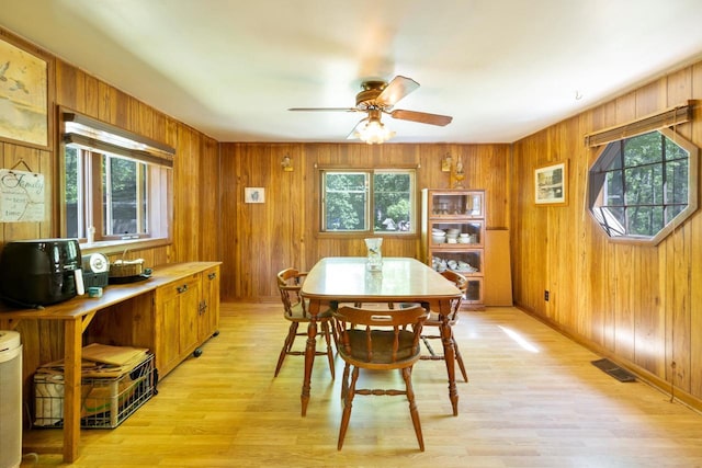 W2761 49th St, Mauston, WI 53948 - dining area with healthy amount of natural light, light wood-type flooring, a ceiling fan, wooden walls, and baseboards