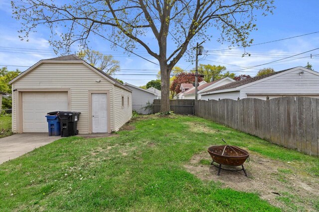 901 William St, Racine, WI 53402 - view of yard with a fire pit, a garage, concrete driveway, and an outdoor structure
