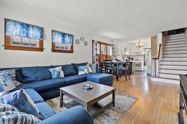 901 William St, Racine, WI 53402 - living area with stairway, a chandelier, and light wood-style floors