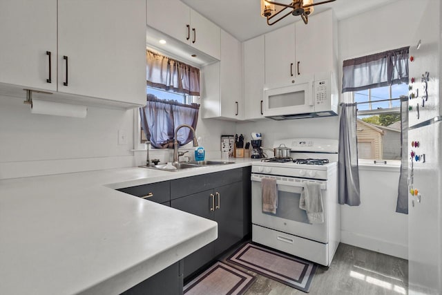 901 William St, Racine, WI 53402 - kitchen featuring white appliances, a sink, healthy amount of natural light, and light countertops