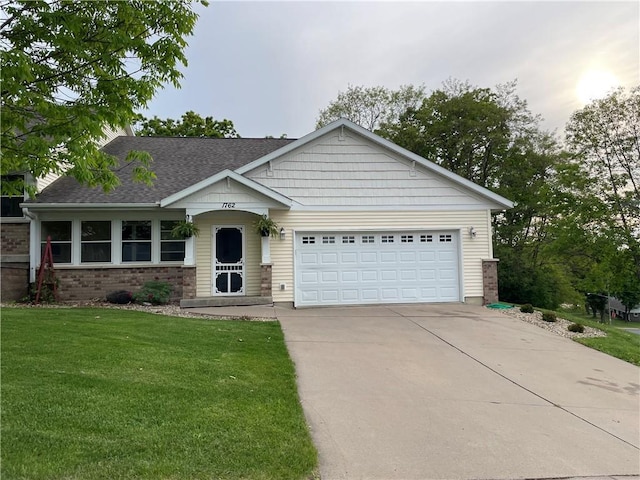 1762 Wilson Ave, Menomonie, WI 54751 - single story home with driveway, a garage, a front yard, brick siding, and a shingled roof