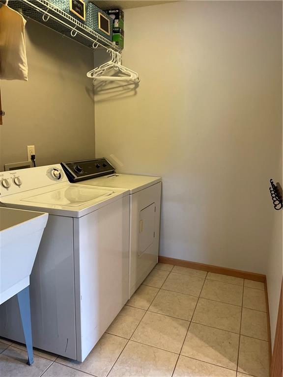 1762 Wilson Ave, Menomonie, WI 54751 - laundry room featuring independent washer and dryer, light tile patterned flooring, and baseboards