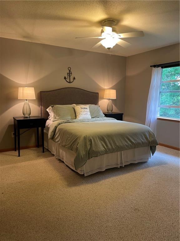 1762 Wilson Ave, Menomonie, WI 54751 - bedroom with light carpet, ceiling fan, baseboards, and a textured ceiling