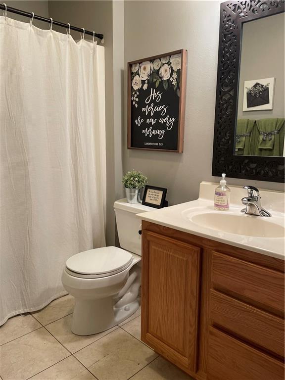 1762 Wilson Ave, Menomonie, WI 54751 - bathroom featuring toilet, vanity, tile patterned floors, and curtained shower