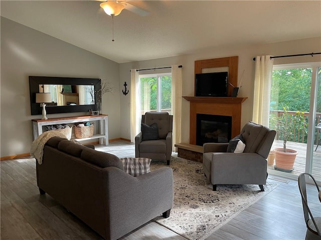 1762 Wilson Ave, Menomonie, WI 54751 - living room featuring lofted ceiling, wood finished floors, a glass covered fireplace, a ceiling fan, and baseboards