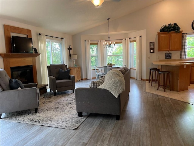 1762 Wilson Ave, Menomonie, WI 54751 - living room featuring lofted ceiling, a chandelier, plenty of natural light, light wood-style flooring, and a glass covered fireplace