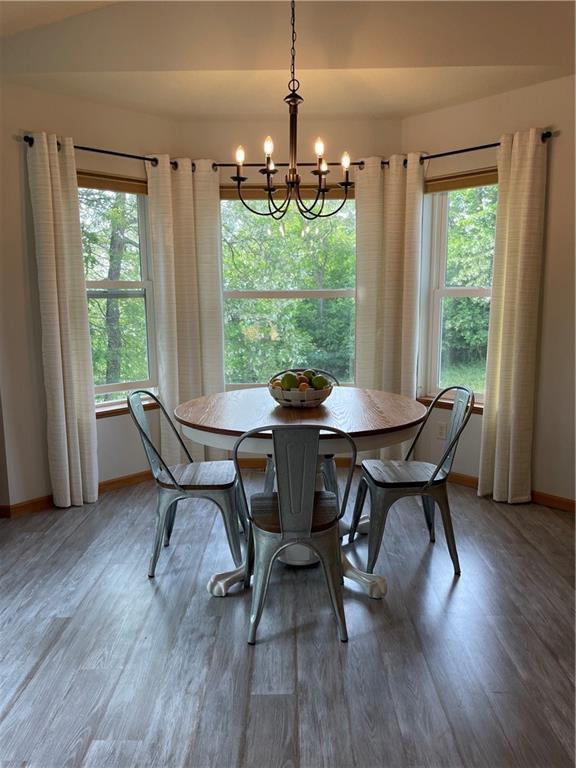1762 Wilson Ave, Menomonie, WI 54751 - dining area featuring a chandelier, baseboards, healthy amount of natural light, and light wood-type flooring