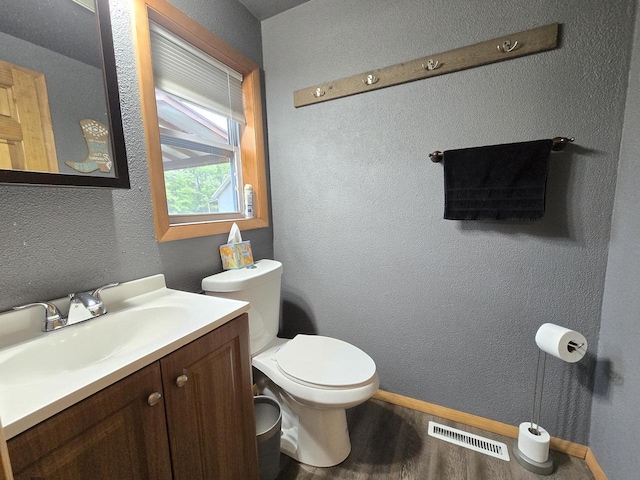 5321 Breezy Pine Dr, Wisconsin Rapids, WI 54494 - half bathroom featuring toilet, vanity, wood finished floors, a textured wall, and baseboards