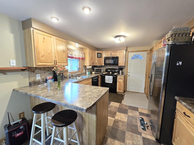 5321 Breezy Pine Dr, Wisconsin Rapids, WI 54494 - kitchen with black appliances, a sink, light brown cabinets, and a peninsula