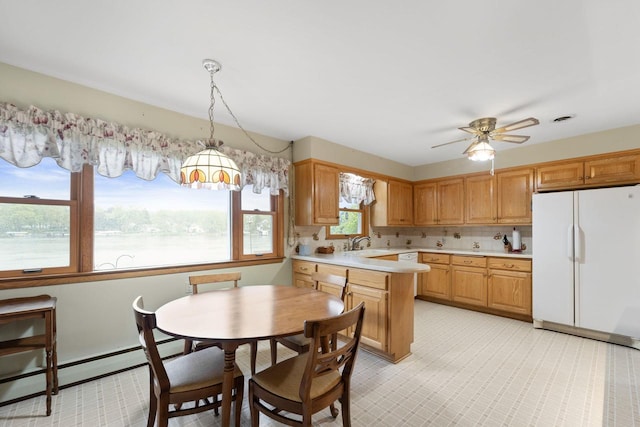 5743 Island View Ct, Waterford, WI 53185 - kitchen with freestanding refrigerator, light countertops, a sink, a ceiling fan, and decorative light fixtures