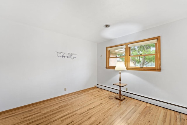 5743 Island View Ct, Waterford, WI 53185 - spare room featuring a baseboard heating unit and wood finished floors