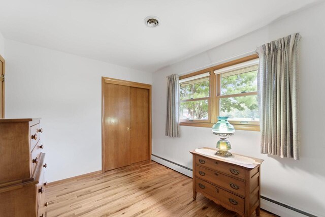 5743 Island View Ct, Waterford, WI 53185 - bedroom featuring a baseboard radiator, light wood-style floors, and a closet