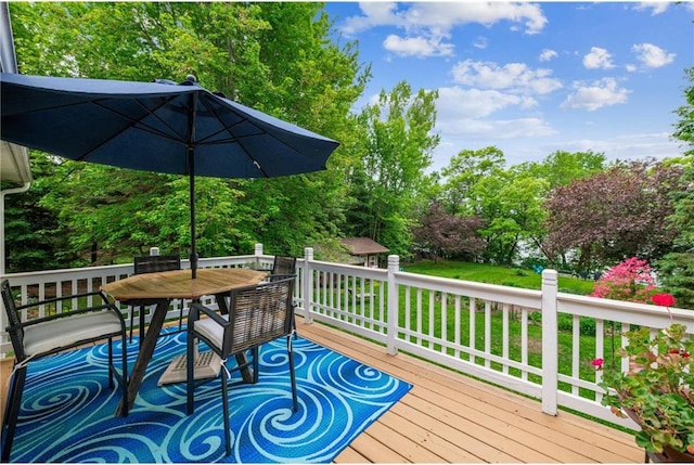 2322 243rd Ave, Cushing, WI 54006 - wooden deck with outdoor dining space, a lawn, and view of scattered trees