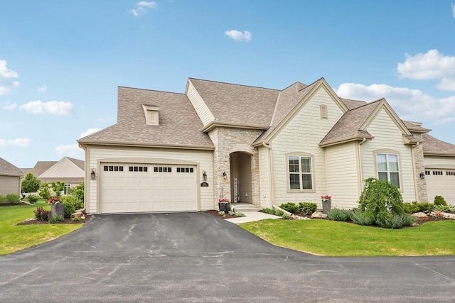 1766 Derby Ln, Oconomowoc, WI 53066 - french provincial home with asphalt driveway, roof with shingles, an attached garage, and a front yard