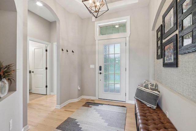 1766 Derby Ln, Oconomowoc, WI 53066 - foyer featuring arched walkways, light wood finished floors, baseboards, and a chandelier