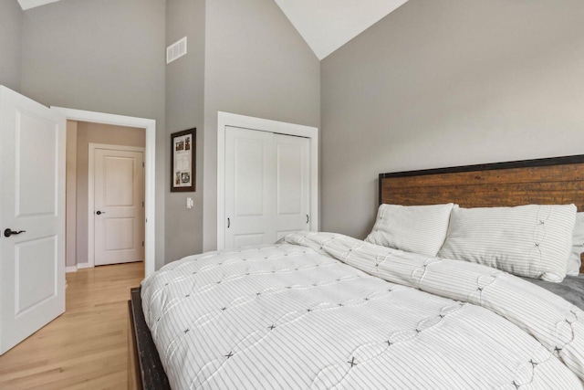 1766 Derby Ln, Oconomowoc, WI 53066 - bedroom with high vaulted ceiling, light wood finished floors, a closet, and baseboards