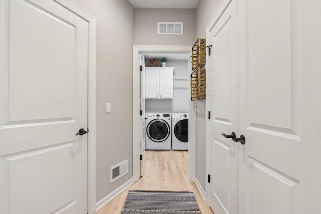 1766 Derby Ln, Oconomowoc, WI 53066 - laundry area featuring light wood-style flooring, washing machine and clothes dryer, cabinet space, and baseboards