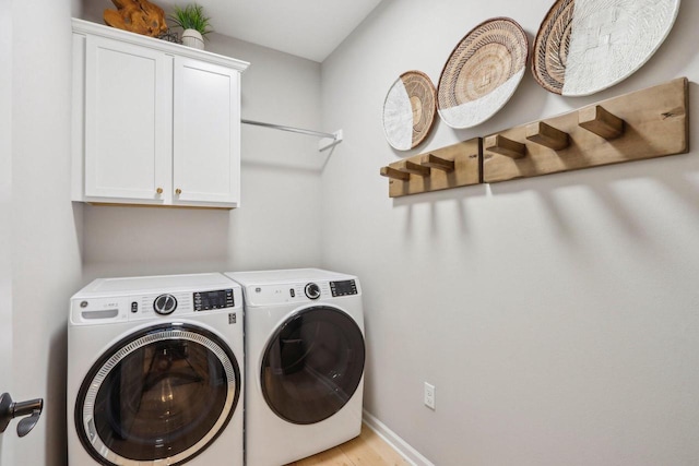 1766 Derby Ln, Oconomowoc, WI 53066 - washroom featuring separate washer and dryer, cabinet space, baseboards, and light wood-type flooring