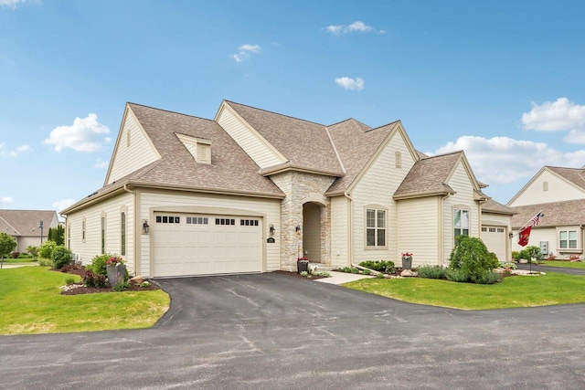 1766 Derby Ln, Oconomowoc, WI 53066 - view of front facade with a front lawn, a shingled roof, asphalt driveway, and an attached garage