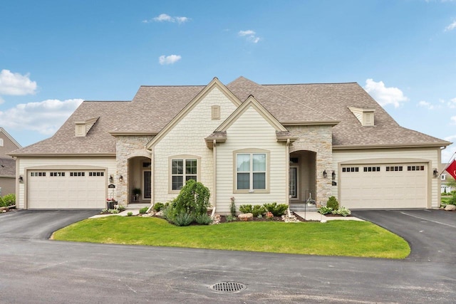 1766 Derby Ln, Oconomowoc, WI 53066 - french country style house featuring asphalt driveway, an attached garage, and stone siding