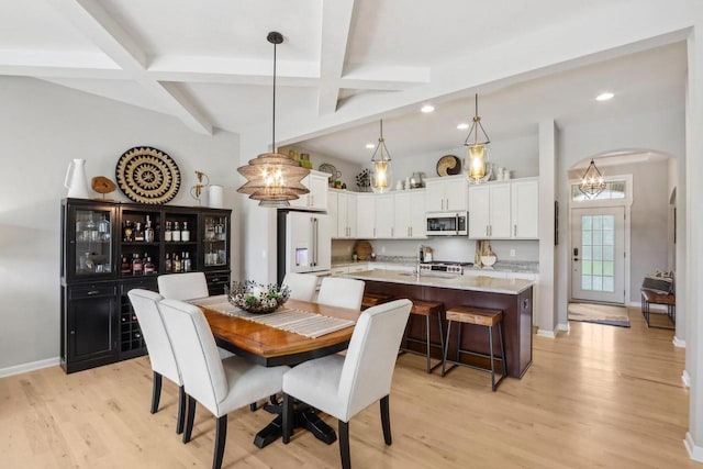 1766 Derby Ln, Oconomowoc, WI 53066 - dining space with light wood-style floors, arched walkways, recessed lighting, beamed ceiling, and baseboards