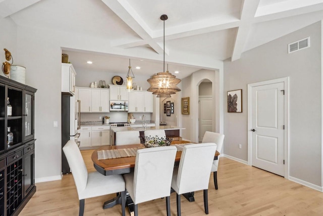 1766 Derby Ln, Oconomowoc, WI 53066 - dining room featuring arched walkways, beam ceiling, baseboards, recessed lighting, and light wood-type flooring
