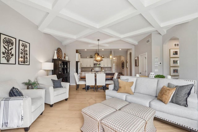 1766 Derby Ln, Oconomowoc, WI 53066 - living room with coffered ceiling, arched walkways, a chandelier, light wood finished floors, and beam ceiling