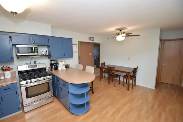 1781 Spruce Ct, South Milwaukee, WI 53172 - kitchen with appliances with stainless steel finishes, blue cabinetry, a peninsula, and open shelves