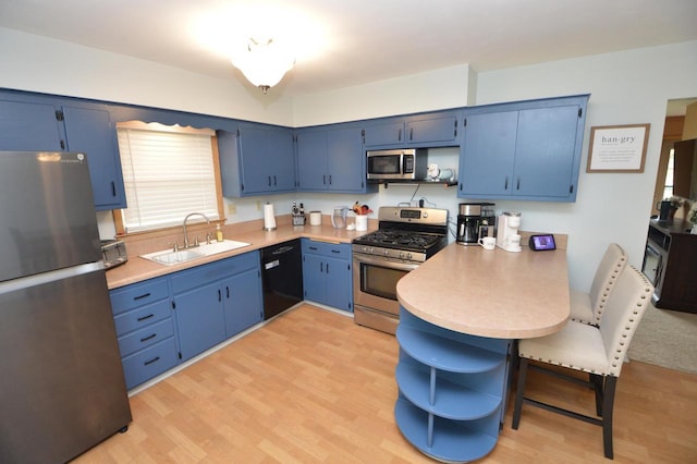 1781 Spruce Ct, South Milwaukee, WI 53172 - kitchen with appliances with stainless steel finishes, a sink, a peninsula, and blue cabinetry