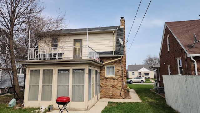 2126 S 16th St, Sheboygan, WI 53081 - rear view of house with a balcony, a chimney, brick siding, and a sunroom