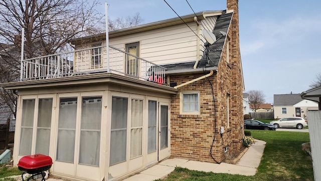 2126 S 16th St, Sheboygan, WI 53081 - rear view of house featuring a balcony, brick siding, a chimney, and a yard