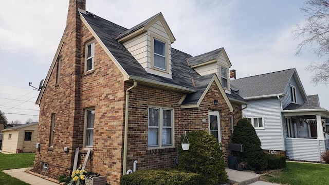 2126 S 16th St, Sheboygan, WI 53081 - view of front of house featuring brick siding, a chimney, and a front yard
