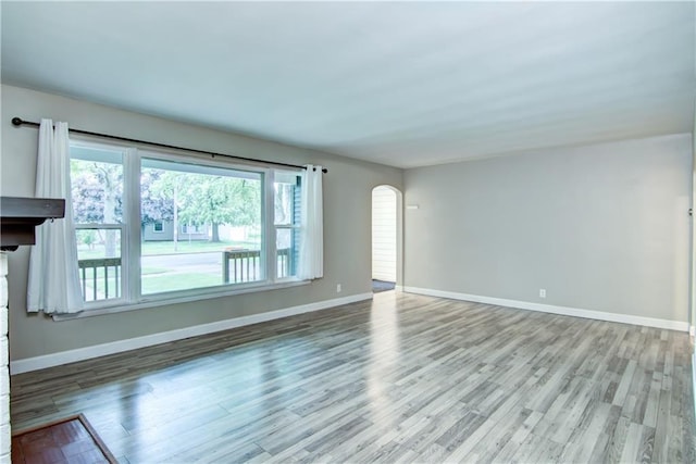 1708 Rist Ave, Eau Claire, WI 54701 - unfurnished living room with arched walkways, wood finished floors, and baseboards