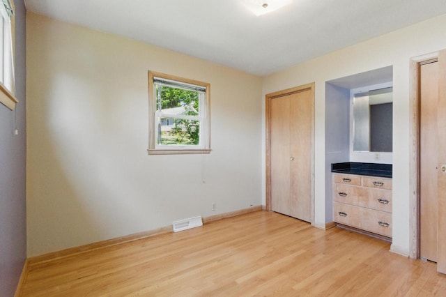 106 Elm St, Westby, WI 54667 - unfurnished bedroom with multiple closets, light wood finished floors, and baseboards