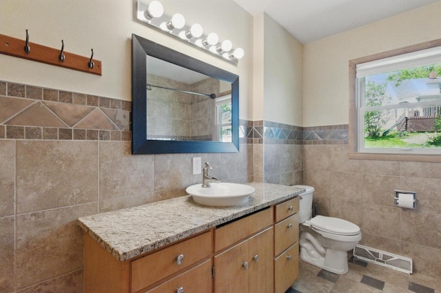 106 Elm St, Westby, WI 54667 - bathroom featuring tile walls, vanity, toilet, a tile shower, and wainscoting