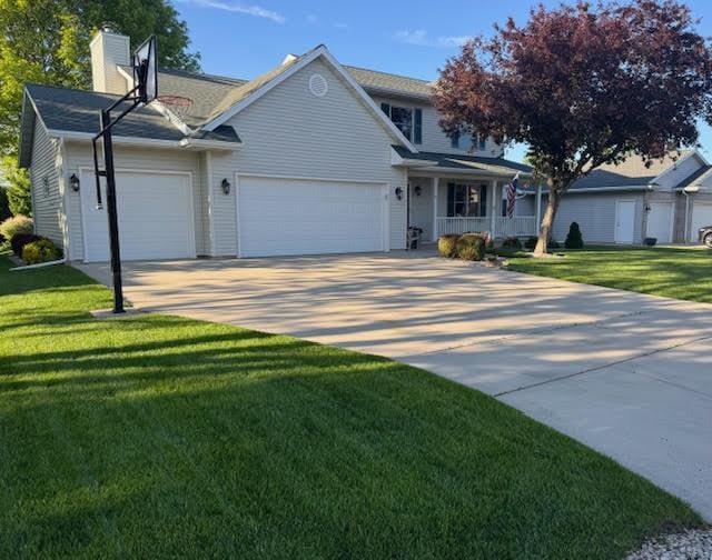 35 Sammy Jo Cir, Fond Du Lac, WI 54935 - view of front of home featuring a garage, a front yard, concrete driveway, and a chimney
