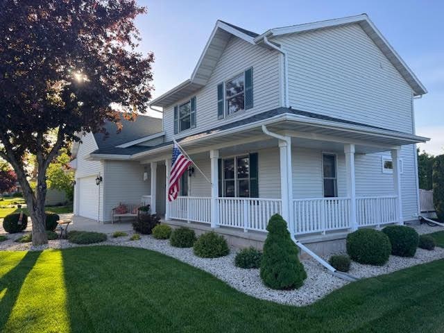 35 Sammy Jo Cir, Fond Du Lac, WI 54935 - view of front of home featuring a porch, a front yard, and an attached garage