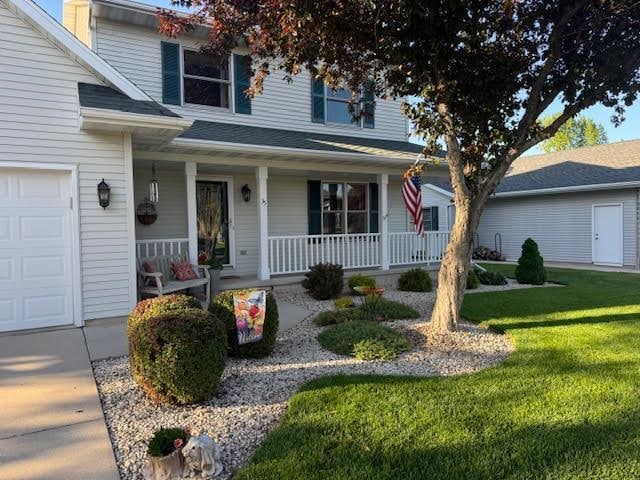 35 Sammy Jo Cir, Fond Du Lac, WI 54935 - view of front of home with covered porch, a garage, and a front yard