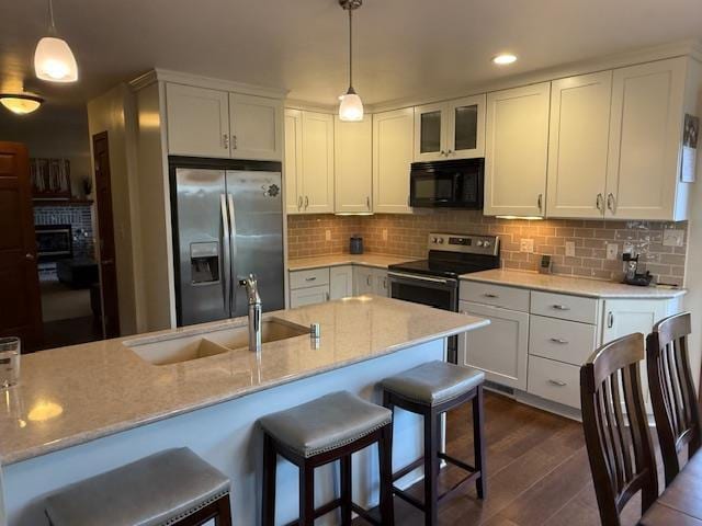 35 Sammy Jo Cir, Fond Du Lac, WI 54935 - kitchen featuring appliances with stainless steel finishes, a sink, dark wood-style floors, a kitchen breakfast bar, and white cabinetry