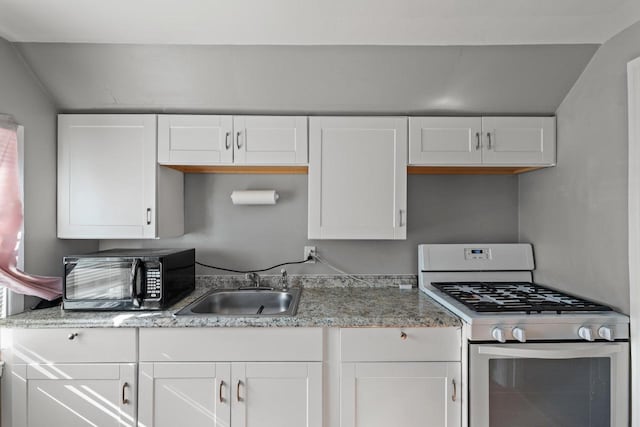 4131 N 41st St, Milwaukee, WI 53216 - kitchen with white gas range oven, black microwave, a sink, white cabinetry, and light stone counters