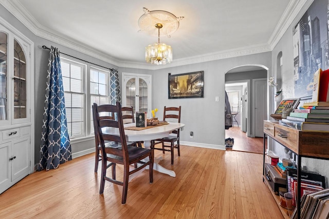 4131 N 41st St, Milwaukee, WI 53216 - dining space with arched walkways, a chandelier, crown molding, light wood-style floors, and baseboards
