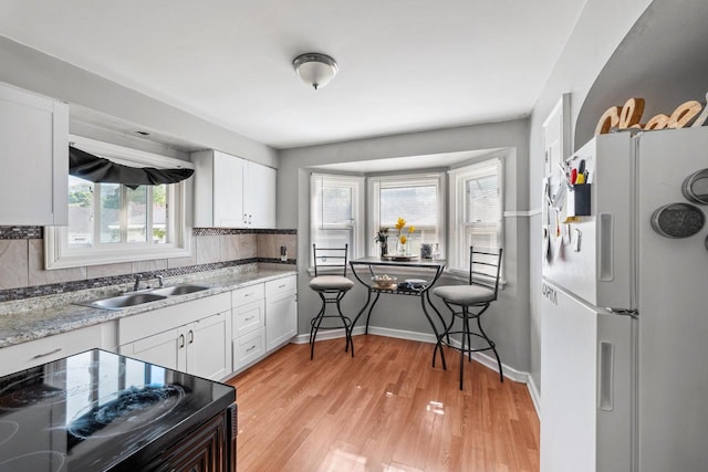4131 N 41st St, Milwaukee, WI 53216 - kitchen featuring freestanding refrigerator, a sink, white cabinets, and decorative backsplash