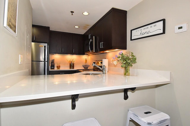 270 E Highland Ave Unit 644, Milwaukee, WI 53202 - kitchen with appliances with stainless steel finishes, a peninsula, a sink, recessed lighting, and light countertops